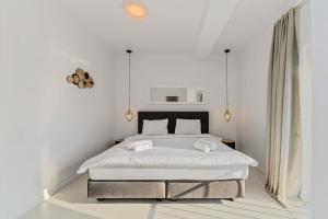 ein weißes Schlafzimmer mit einem Bett mit zwei Handtüchern darauf in der Unterkunft MoHost Harmony Apartments - Brasov City Center in Braşov + 22 Fotos