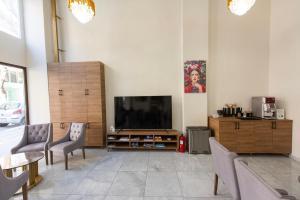 Televízia a/alebo spoločenská miestnosť v ubytovaní Nea Metropolis