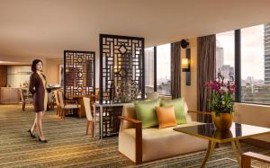 a woman standing in a room with a living room at Mandarin Oriental, Jakarta in Jakarta