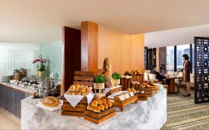 a bakery with bread and pastries on a counter at Mandarin Oriental, Jakarta in Jakarta