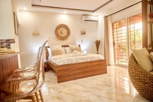 a bedroom with a bed and a chair in it at Résidence Alicia Grand studio luxueux et élégant in Bingerville