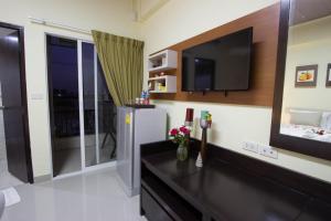 a living room with a flat screen tv and a large mirror at AA Resort Hotel นนทบุรี in Ban Pratu Nam Phra Udom