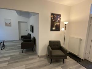 a waiting room with two chairs and a tv at Haus Schönborn Norden Family in Norden