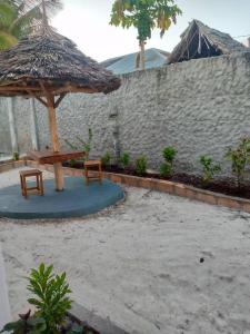 a table and two chairs under an umbrella at Uroa House in Uroa
