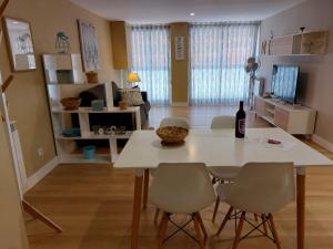 a living room with a table and a bottle of wine at Apartamentos Nájera in Nájera +6 photos