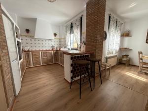 a kitchen with a counter and chairs in a room at Apartamentos Turísticos Espinel Free Parking in Ronda