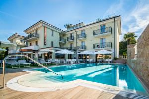 een hotel met een zwembad voor een gebouw bij Hotel Eden Garda in Garda