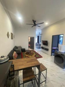 a living room with a couch and a ceiling fan at Laman tokma in Kota Bharu +4 photos