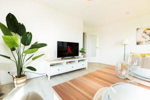 soggiorno con TV a schermo piatto e armadio bianco di Idyllische-Ferienwohnung-am-Schaalsee-Natur-und-Erholung-pur a Zarrentin