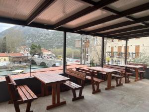 a group of wooden tables and benches on a balcony at Apartment Stari Konak in Virpazar