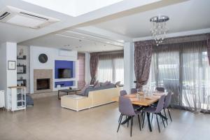 a dining room and living room with a table and chairs at Villa Elena in Triánta