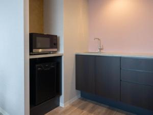 a kitchen with a sink and a tv on a counter at Loisir Hotel Kyoto Toji in Kyoto