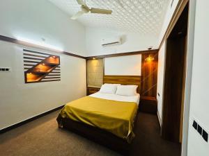a bedroom with a bed with a yellow blanket at The Mallika Holidays in Mananthavady +8 photos
