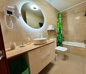 a bathroom with a sink and a toilet and a mirror at Almadrava Beach in Roses