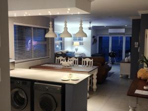 a kitchen and living room with a washer and dryer at Frinton on Sea 12 in Ballito +18 photos