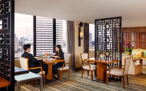 two people sitting at a table in a restaurant at Mandarin Oriental, Jakarta in Jakarta