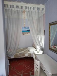 Myrto's house في لياباديس: غرفة صغيرة بها سرير مع ستائر وكعكة +22 صورة
