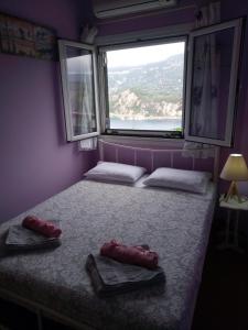 Myrto's house في لياباديس: سرير في غرفة مع وسادتين ونافذة