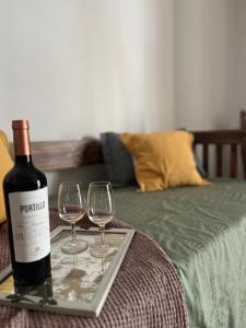 a bottle of wine and two wine glasses on a tray at Departamento Inigualable en Ciudad de Mendoza in Barraquero