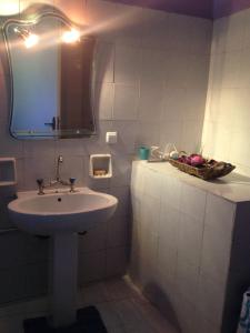 Myrto's house في لياباديس: حمام مع حوض ومرآة وسلة فاكهة