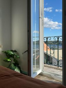 une chambre avec vue sur l'océan depuis un balcon dans l'établissement Belém Apartment with Tagus River View, à Lisbonne