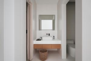 a bathroom with a sink and a mirror and a toilet at Shenzhen INNOGYM Hotel in Shenzhen
