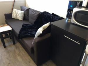 un sofá en una sala de estar con encimera negra en VA THORENS studio SUD VUE 180 WIFI, en Val Thorens 5 fotos más