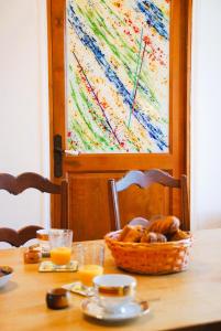 a table with a basket of bread and a basket of orange juice at Grande maison escapade au bord de la riviere in Touvre