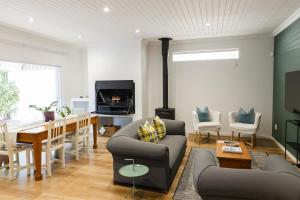 a living room with a fireplace and a dining room at Cherry Blossom Boutique Stay, Ceres in Ceres