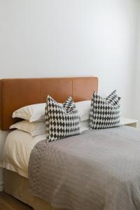 a bed with three pillows on top of it at Cherry Blossom in Ceres