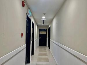 an empty hallway with a black door and a hallwayngth at ATAP Hotel in Kota Kinabalu