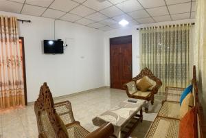 a living room with chairs and a couch and a tv at Cozy home in Badulla