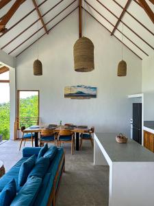 a living room with a blue couch and a table at Villa Treetop, 2BR with spectacular ocean view in Nusa Penida