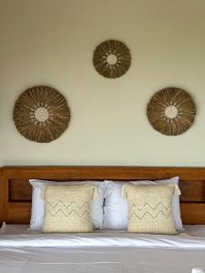a bedroom with a bed with two plates on the wall at Villa Treetop, 2BR with spectacular ocean view in Nusa Penida +28 photos