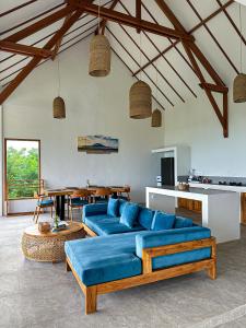 a living room with a blue couch and a table at Villa Treetop, 2BR with spectacular ocean view in Nusa Penida