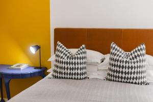 a bed with two black and white pillows on it at Cherry Blossom in Ceres