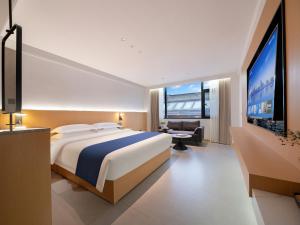 a bedroom with a large bed and a flat screen tv at Zhangjiajie Zhenxi Hotel- Near Forest Park EastGate about 10 Min Walk - English Butler, Free Luggage Storage, Tour Plan -reserve tickets for various scenic spots-Self-Service Laundry,Free coffee, Chinese tea in Zhangjiajie