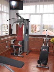 een kamer met een fitnessruimte met een loopband en een stoel bij Hotel Okatex in Żagań