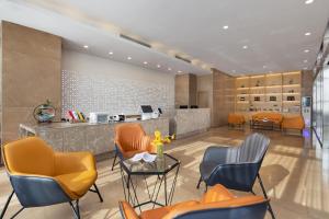 a waiting room with orange chairs and a counter at Manston Hotel Gaoxin Science Avenue Subway Station Branch in Hefei