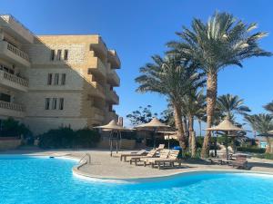 a resort with a swimming pool and palm trees at vintage sea view apartment in Hurghada