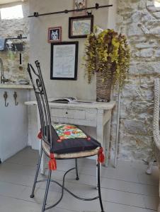 einem Stuhl vor einem Schreibtisch mit einer Vase aus Blumen in der Unterkunft Le Mas Saint Pierre in Roquefort-les-Pins