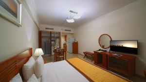 a bedroom with a bed and a flat screen tv at Rose Garden Hotel Apartments - Bur Dubai in Dubai