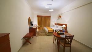 a hotel room with a bed and a desk and a table at Rose Garden Hotel Apartments - Bur Dubai in Dubai