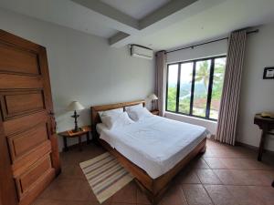 a bedroom with a bed and a large window at Serene Reach Villa in Kandy