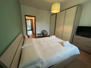 a bedroom with a large white bed and a television at 3T House 2 Casa Vacanze in Cremona