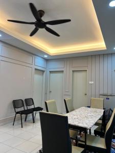 ein Esszimmer mit einem Deckenventilator sowie einem Tisch und Stühlen in der Unterkunft Pink Castle Adelia Bangi Avenue in Kampong Batu Lima Bangi + 7 Fotos