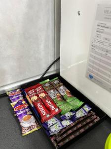 eine Schublade voller Chips und anderer Snacks neben einem Kühlschrank in der Unterkunft Pink Castle Adelia Bangi Avenue in Kampong Batu Lima Bangi