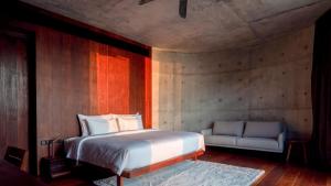 ein Schlafzimmer mit einem Bett und einer Couch in der Unterkunft Vows Villa Beachfront in Ban Bang Po