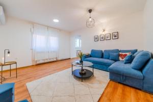 a living room with a blue couch and a table at Peaceful Nest In City Center - Happy Rentals in Zagreb