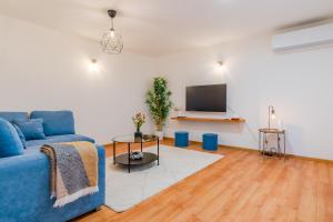 a living room with a blue couch and a tv at Peaceful Nest In City Center - Happy Rentals in Zagreb